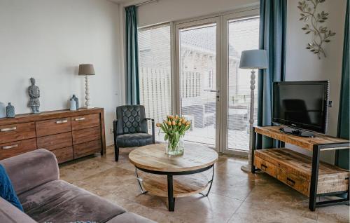 a living room with a couch and a tv and a table at Flat Fish in Egmond aan Zee