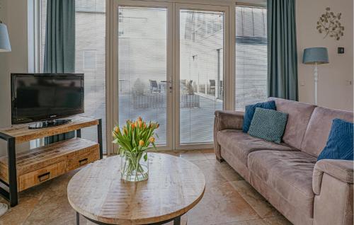 a living room with a couch and a table with a tv at Flat Fish in Egmond aan Zee