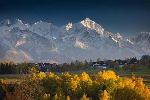 a mountain range in the distance with houses and trees at Czerwone Wierchy - sauna i jacuzzi wliczone w cenę pobytu - blisko stoku narciarskiego - zachęcamy do rezerwacji zimowych pobytów w atrakcyjnych cenach! in Białka Tatrzanska