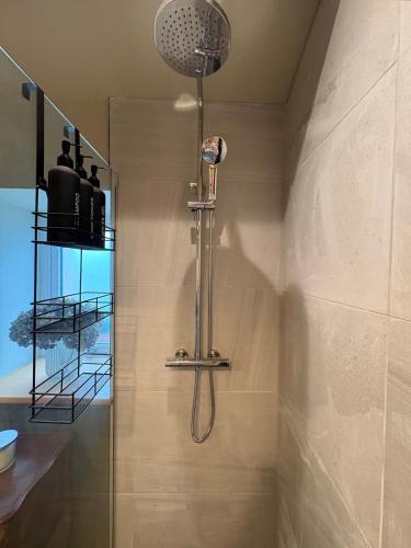 a shower with a shower head in a bathroom at Holly Cottage - Village location, Lake District in Penrith
