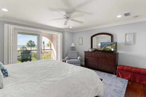 ein Schlafzimmer mit einem Bett, einer Kommode und einem Spiegel in der Unterkunft Big Blue - 1108 Beachview Drive in Demere Park