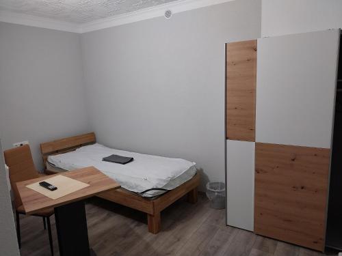 a small bedroom with a bed and a desk at Monteurwohnung Kotte in Thiendorf