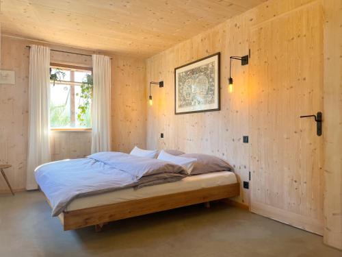 a bedroom with a bed in a wooden wall at Architektenhaus Reischl mit Sauna in Neubeuern
