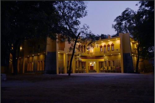 a lit up building with a tree in front of it at Estherea Bagh Ranthambhore Tiger Territory in Sawāi Mādhopur