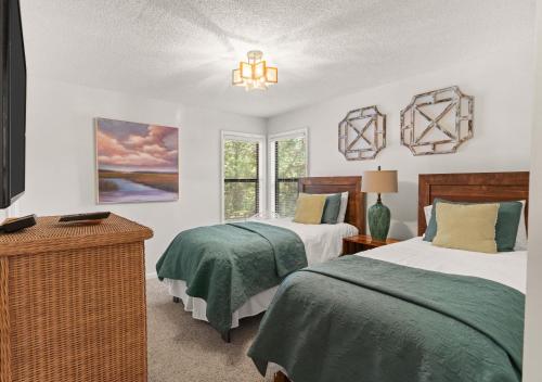 Harbour Oaks, Unit 618 في Demere Park: غرفة نوم بها سريرين وثريا