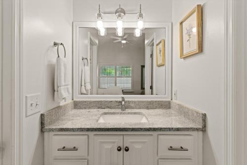 a bathroom with a sink and a large mirror at Point Five - 1133 Mallery St in Saint Simons Island