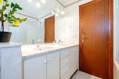 a bathroom with two sinks and a wooden door at Villa Ponent in Calafat