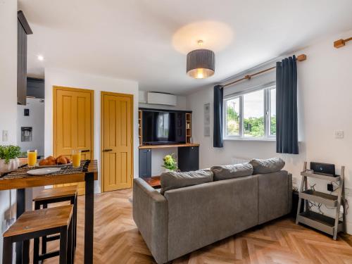 a living room with a couch and a table at The May Tree in South Creake