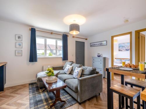 a living room with a couch and a table at The May Tree in South Creake
