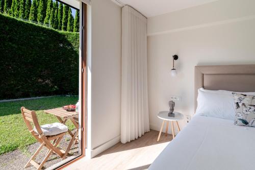 une chambre avec un lit et une porte coulissante en verre dans l'établissement Quinta do Outeirinho - Villa Deluxe, à Celorico de Basto