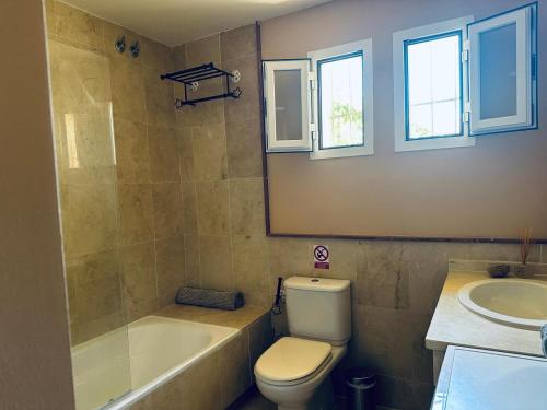 a bathroom with a toilet and a tub and a sink at Beautiful House With Splendid Sea in La Herradura