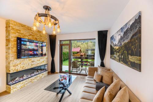 a living room with a couch and a fireplace at Ama Garden Spa Apartment Busteni in Buşteni