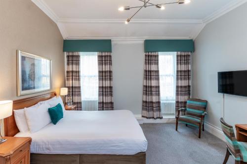 a bedroom with a bed and a desk and a tv at The Craiglands Hotel Sure Hotel Collection by Best Western in Ilkley