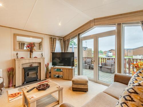 a living room with a fireplace and a tv at Woodlands in Sewerby