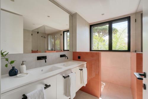 un baño con lavabo y espejo en Cascais Contemporary Villa by Cadenzalux, en Torre