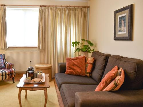 ein Wohnzimmer mit Sofa und Tisch in der Unterkunft Hollyhock Cottage in Tenterden
