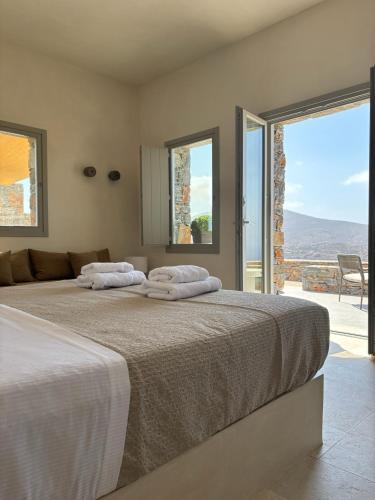 two beds in a bedroom with a view of the mountains at Pentanemi Folegandros in Áno Meriá