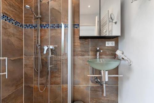 a bathroom with a sink and a shower at Häuschen Seerobbe in Sankt Peter-Ording