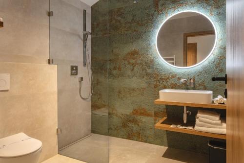 a bathroom with a shower and a sink and a mirror at Hotel Bronzo Brno in Brno