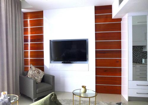 a living room with a tv on a wall at ITowers Luxury Apartment 2 in Gaborone