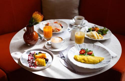 a table with plates of breakfast food on it at NYX Hotel Rome by Leonardo Hotels in Rome