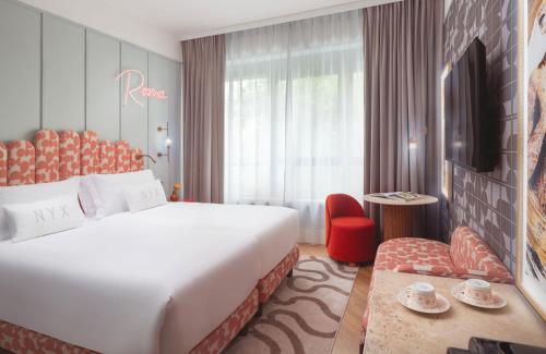 ein Hotelzimmer mit einem großen Bett und einem Fernseher in der Unterkunft NYX Hotel Rome by Leonardo Hotels in Rom