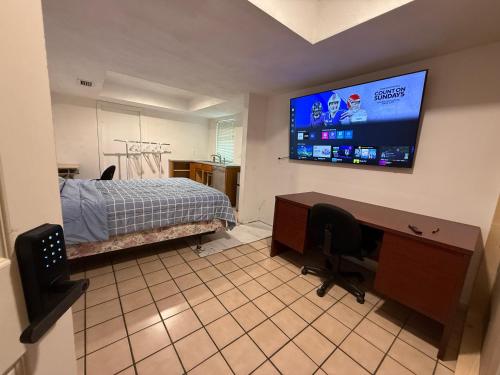 a bedroom with a bed and a desk and a flat screen tv at Happy Vacation in Largo