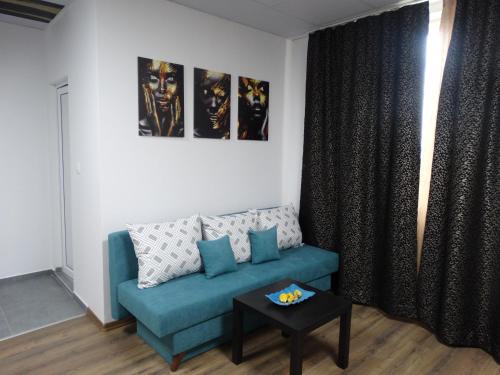 a living room with a blue couch and a table at Hostel Tsanovi in Pleven