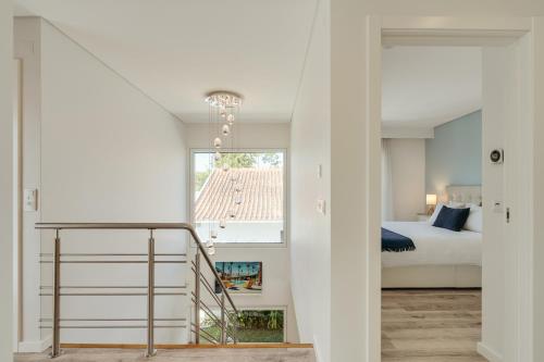 Eine Treppe führt zu einem Schlafzimmer mit einem Bett. in der Unterkunft Paraty Villa in Aroeira
