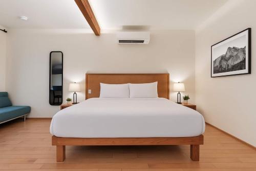 a bedroom with a large white bed and a blue couch at Snowcreek Suite - Cedar - ADA- Hot Tub - Kitchenette in Leavenworth