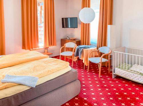 a bedroom with two beds and a table and chairs at Hotel Carlsruh in Braunlage