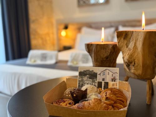a box of pastries on a table with two candles at Porta 20 Boutique Guesthouse in Leiria