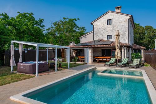 a swimming pool in front of a house at Villa Histria, a wonderful and luxurious villa in Manjadvorci
