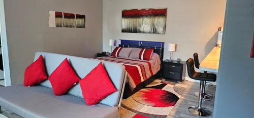 um quarto com uma cama e um sofá com almofadas vermelhas em Modern Condo, Private, Home Feel, No Shared Walls em Katy