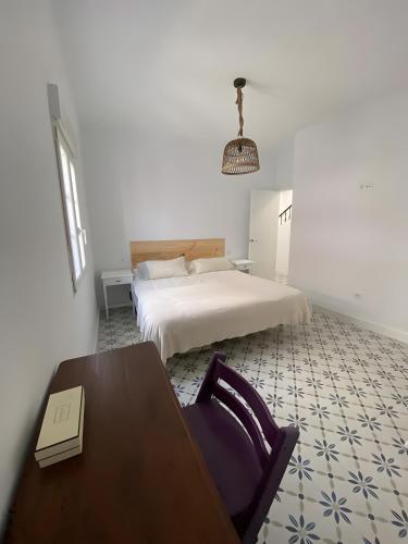 a bedroom with a bed and a table and a chair at Casa Típica con Terraza in Ayamonte