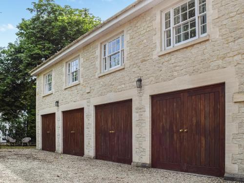 un bâtiment en briques avec trois portes de garage dans l'établissement Flat 1 - Uk50224, à Tetsworth