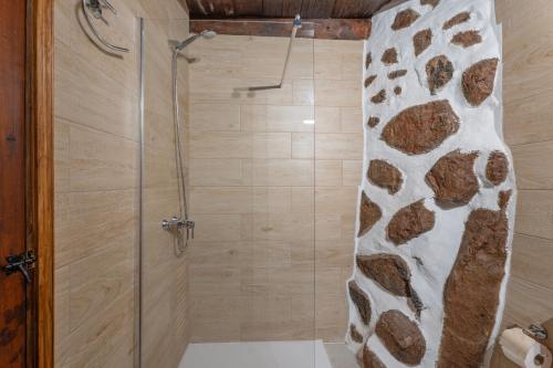 a bathroom with a shower with a stone wall at La Generosa in Arona