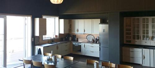a kitchen with white cabinets and a table and chairs at Renovated Chapel With Fjord Views In Vågstranda in Reistad