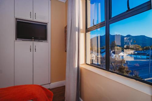 a bedroom with a window with a view of a city at 17onWellington Apartments in George