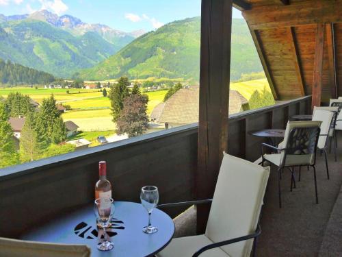 a table with a bottle of wine and glasses on a balcony at Wohl eingerichtete Wohnung mit eigenem Balkon in Sankt Michael im Lungau