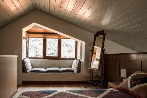 un dormitorio con una ventana con un banco enfrente en Guesthouse Vasiliki, en Stení Dhírfios