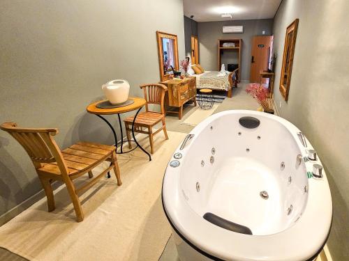 a living room with a bath tub and chairs at Hotel Verdes Mares in Ouro Branco