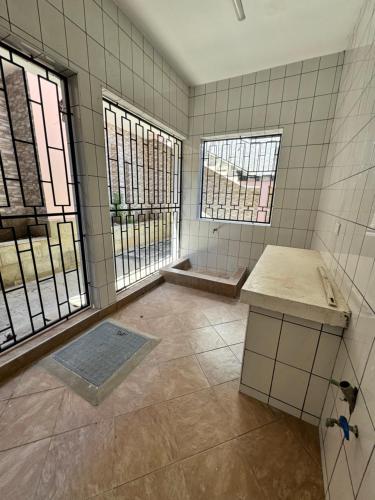 an empty bathroom with two windows and a shower at Shuja Ranches in Kilifi