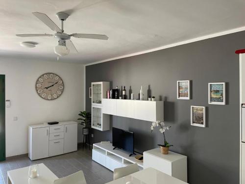 a living room with a ceiling fan and a clock at Casa Real in Playa Blanca