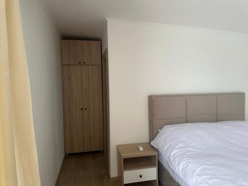 a bedroom with a bed and a wooden cabinet at Daisy 1 in Banja Luka