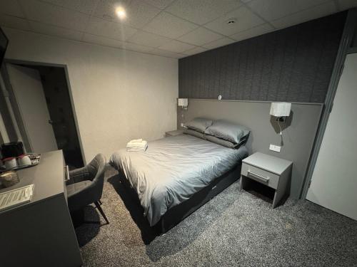 ブラックプールにあるWaverley Beach Hotelのベッドと椅子のある小さな寝室