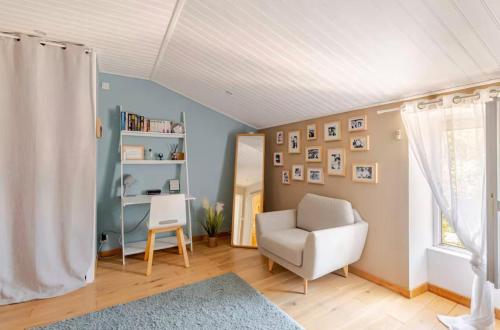a living room with a chair and a book shelf at Longère de charme avec piscine, proche océan in Lairoux
