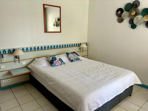 a bedroom with a bed with two pillows on it at Studio Carayou Pointe du Bout Les Trois-Ilets in Les Trois-Îlets