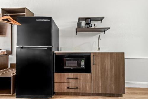 a kitchen with a black refrigerator and a microwave at Studio 6 Hammond, LA I12 I55 in Hammond