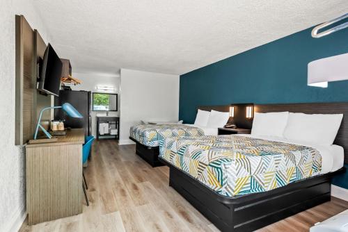 a hotel room with two beds and a tv at Studio 6 Hammond, LA I12 I55 in Hammond